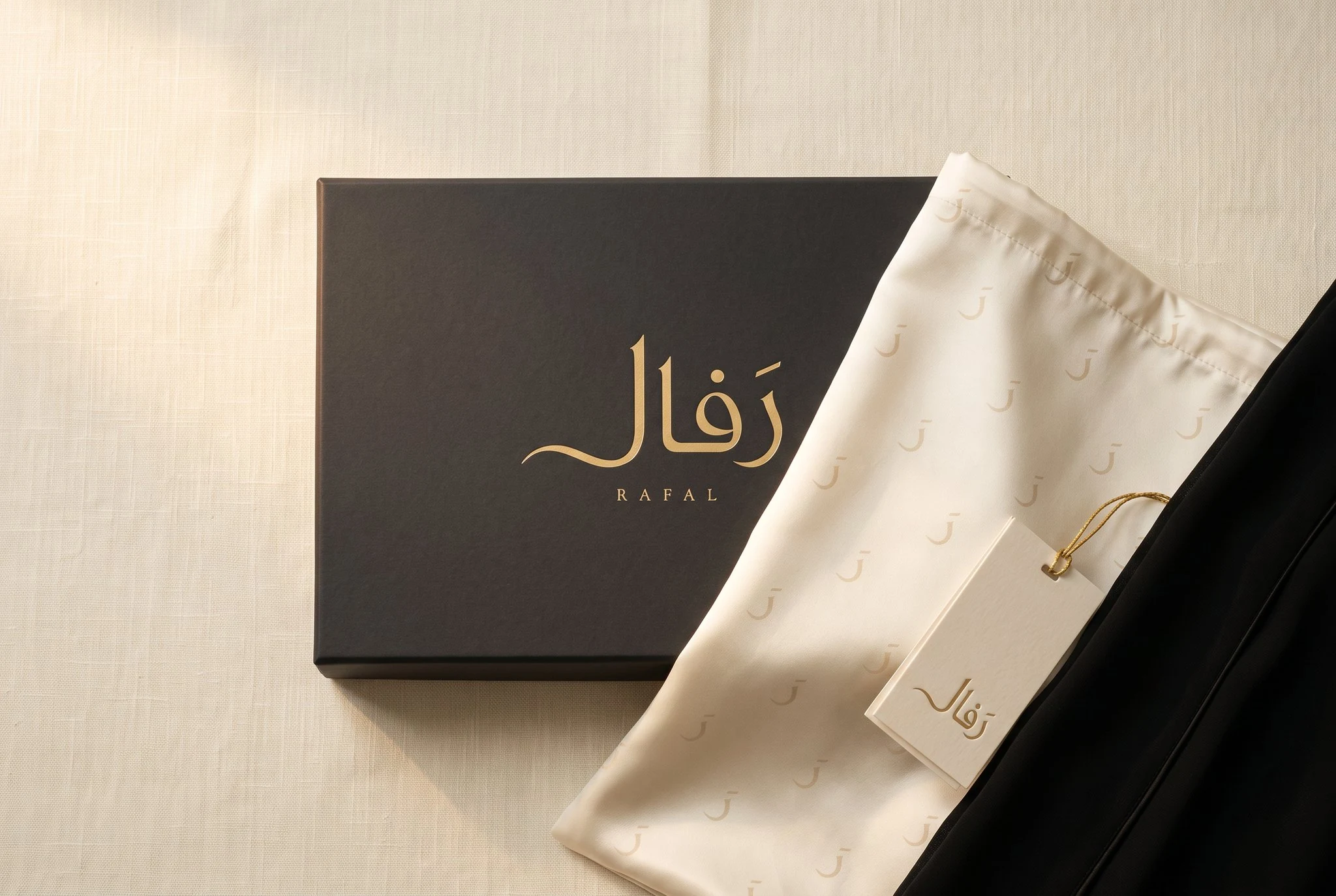 نظام الإهداء: علبة فحمية بختم الذهب، وكيس قماشٍ عاجي يلبس نقش راء الدار.