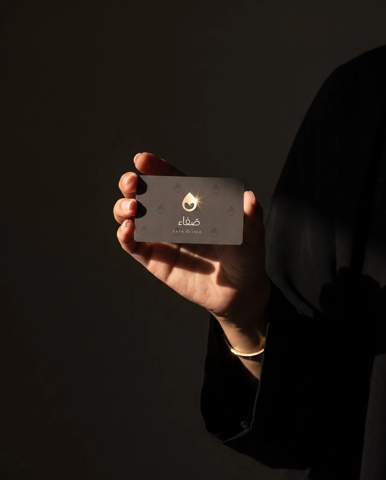 بطاقة العيادة تخرج من العتمة إلى الشعاع: فويل الشمبانيا يلتقط الومضة، والاسم يُقرأ بهدوء.